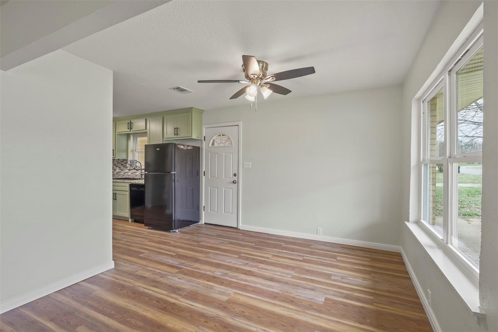 732 Bullock Street Denison, TX 75020 - Photo 6 of 29 a view of a kitchen with a ceiling fan wooden floor and a ceiling fan