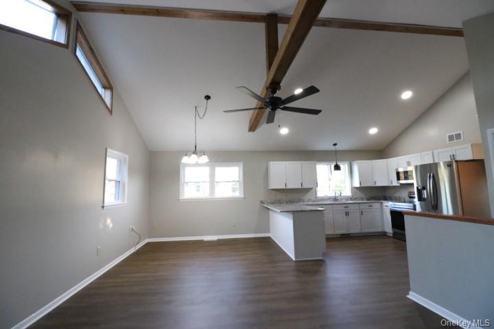 a kitchen with stainless steel appliances kitchen island hardwood floor sink stove and wooden cabinets