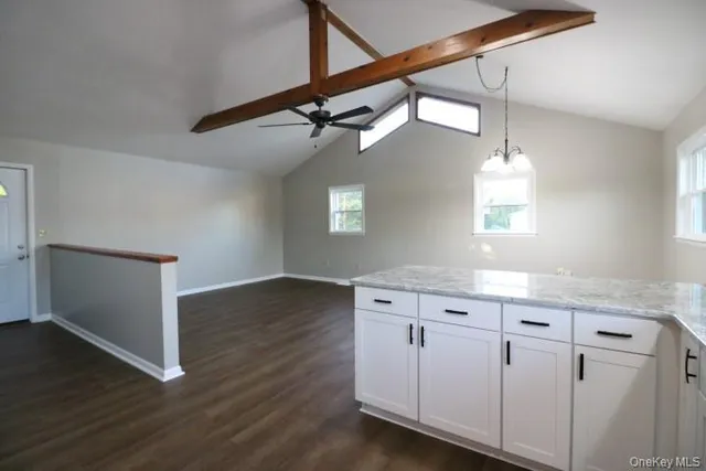 a kitchen with white cabinets and chandelier