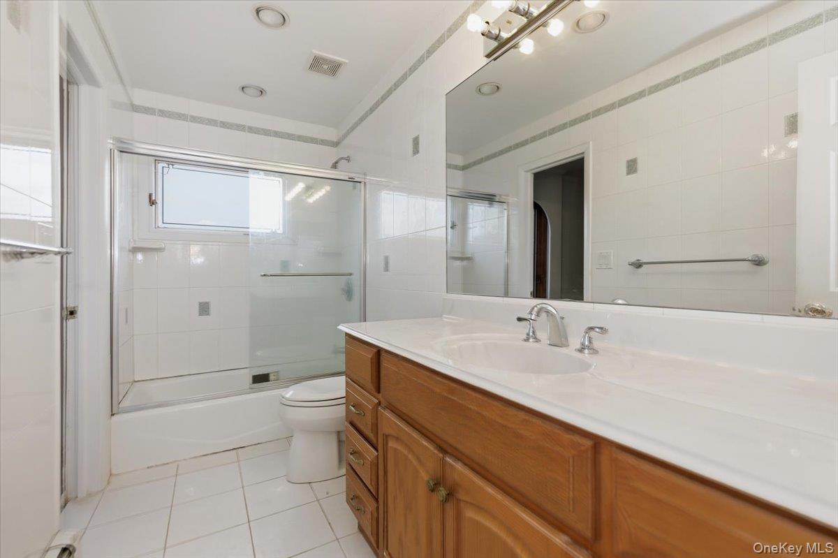 930 Jewel Drive Valley Stream, NY 11581 - Photo 22 of 32 a bathroom with a double vanity sink toilet and shower