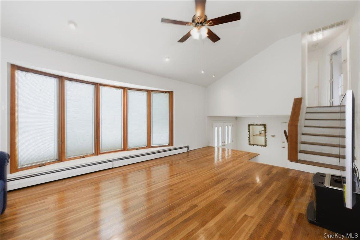 930 Jewel Drive Valley Stream, NY 11581 - Photo 6 of 32 a view of an empty room with a window and wooden floor