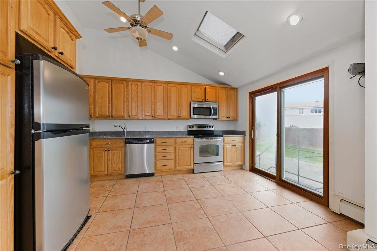 930 Jewel Drive Valley Stream, NY 11581 - Photo 9 of 32 a kitchen with granite countertop a refrigerator and stainless steel appliances