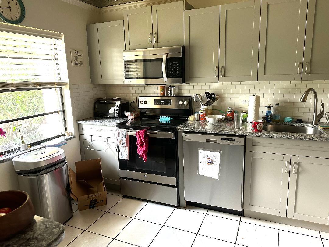 21848 Arriba Real, Unit A Boca Raton, FL 33433 - Photo 2 of 10 a kitchen with stainless steel appliances granite countertop a stove a sink and a microwave