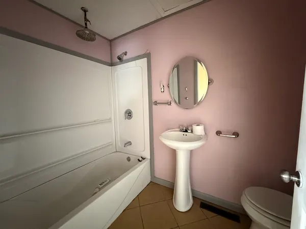 a bathroom with a sink a toilet and shower