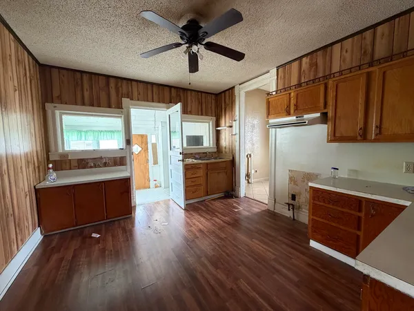 a kitchen with stainless steel appliances granite countertop a refrigerator a stove and a wooden floors