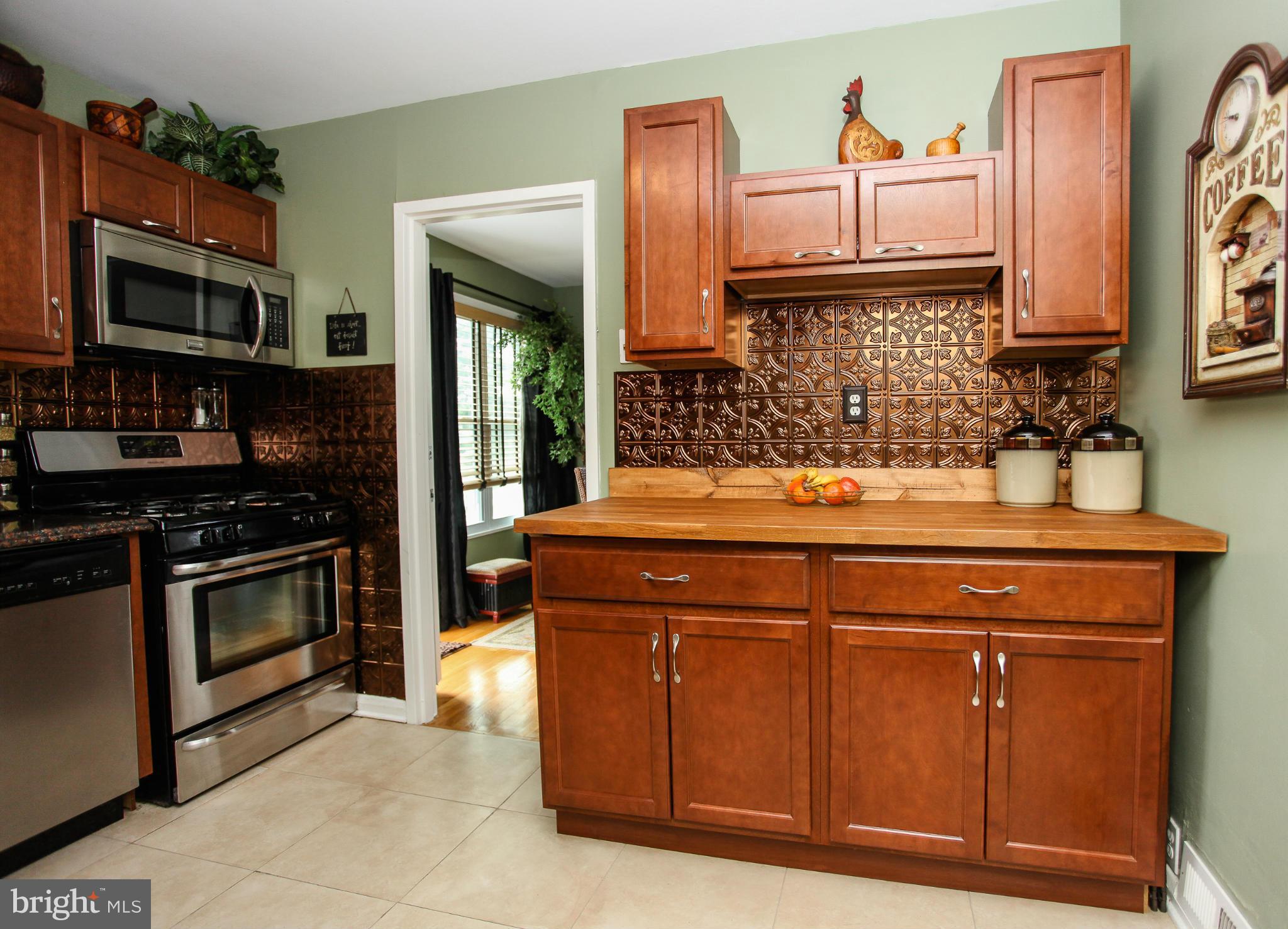 938 Vanderwood Road Baltimore, MD 21228 - Photo 11 of 26 a kitchen with stainless steel appliances granite countertop a stove and a microwave