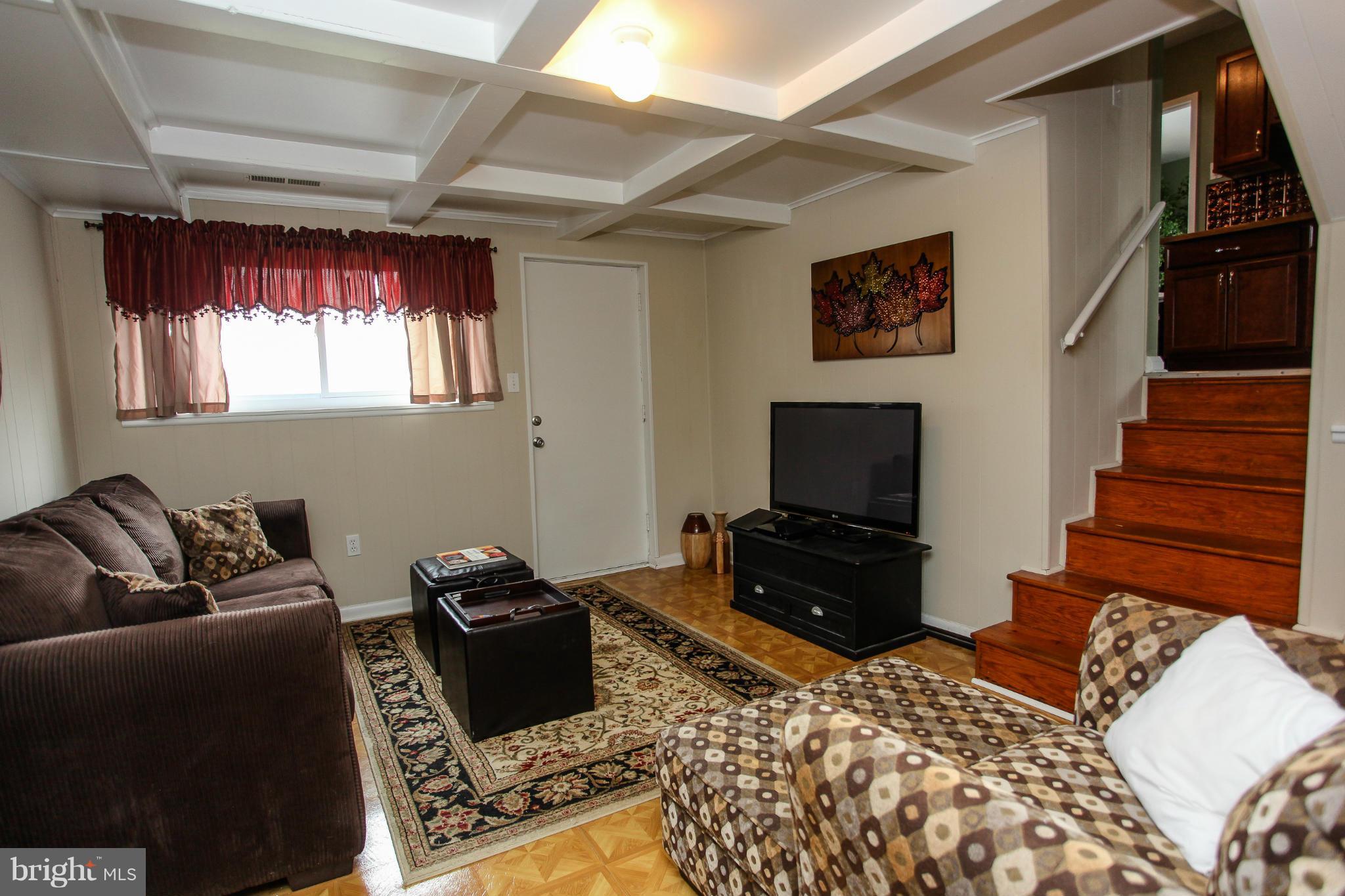 938 Vanderwood Road Baltimore, MD 21228 - Photo 13 of 26 a living room with a couch and a flat screen tv