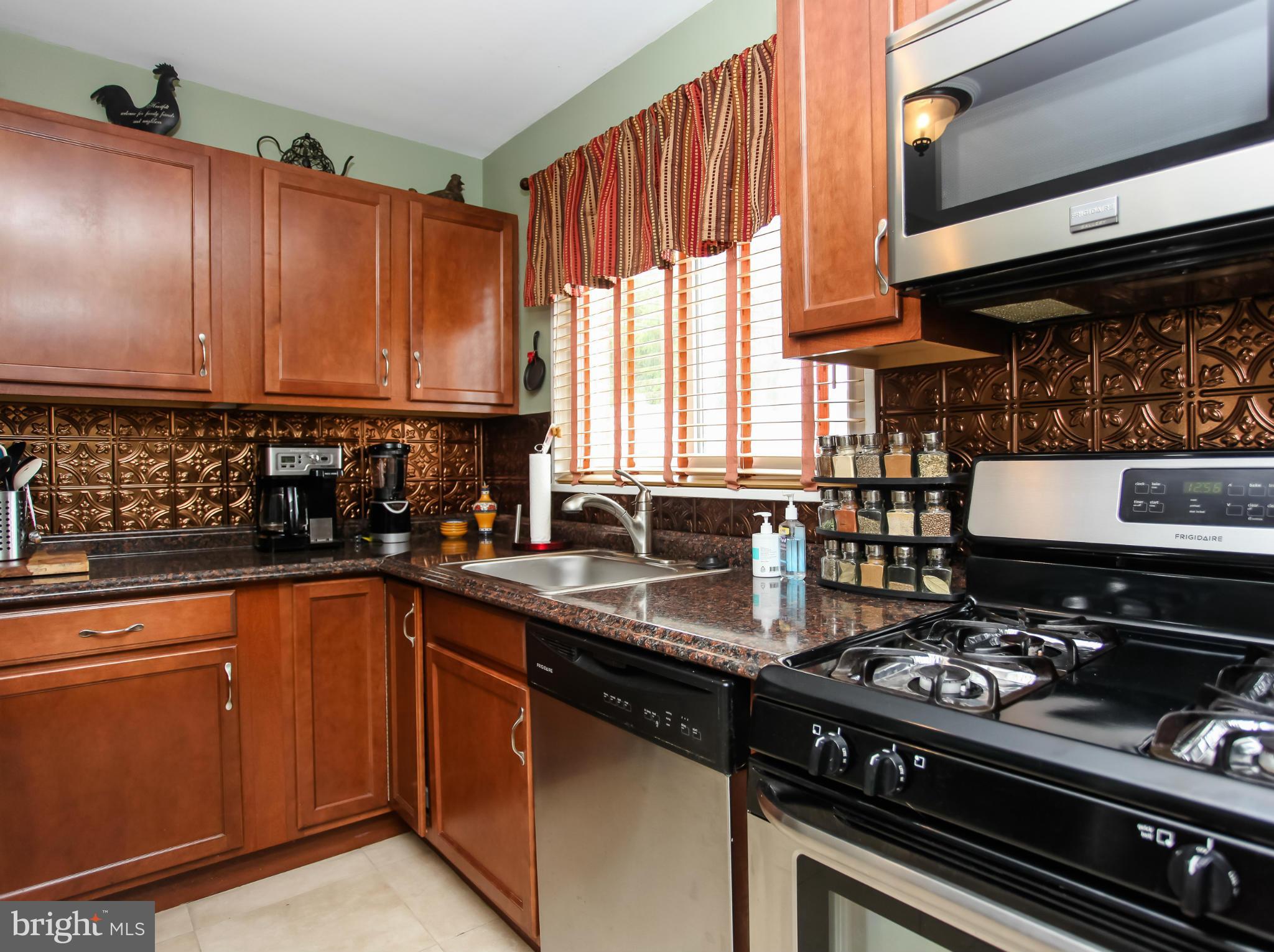 938 Vanderwood Road Baltimore, MD 21228 - Photo 9 of 26 a kitchen with stainless steel appliances a sink stove and cabinets