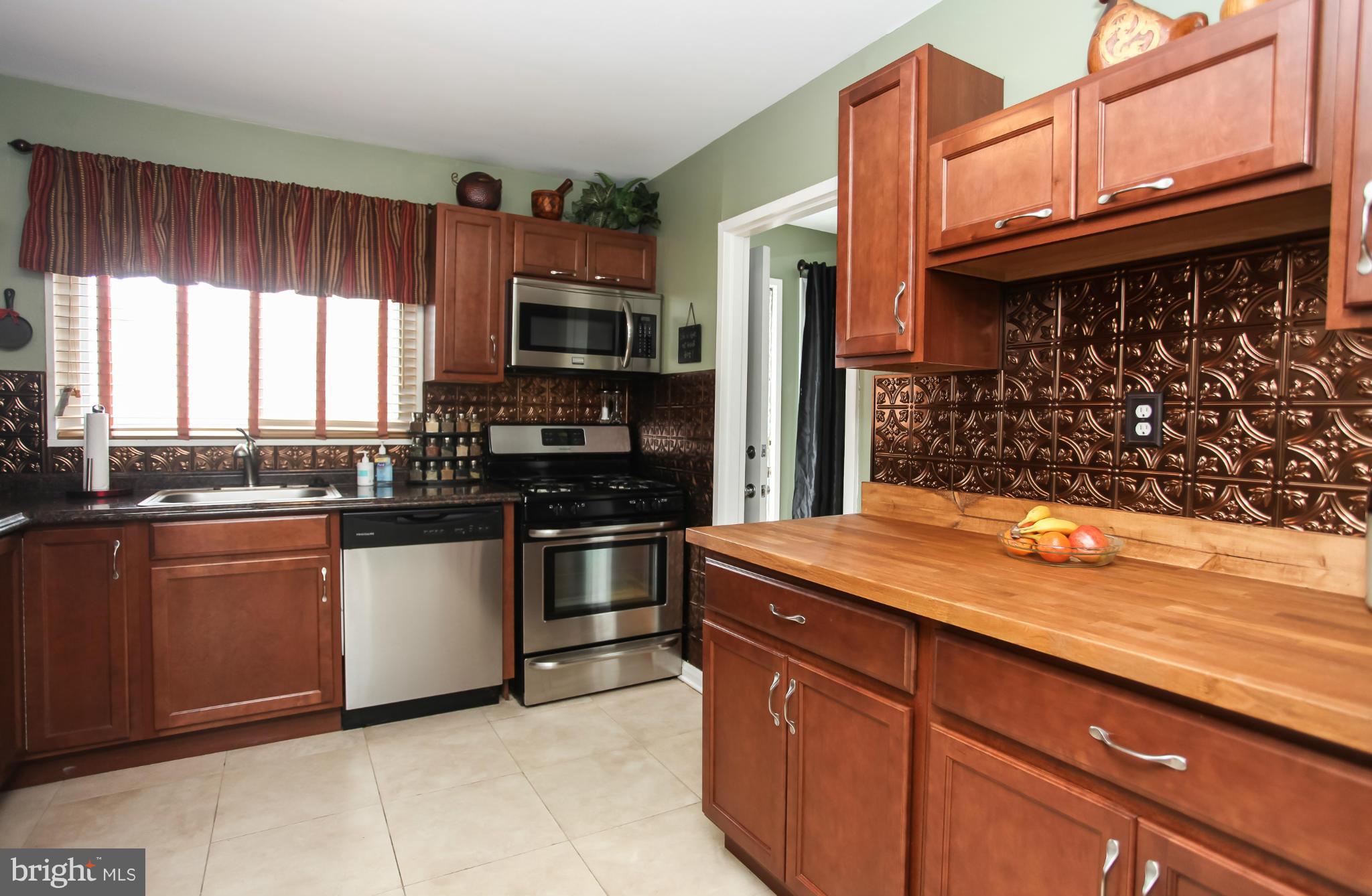 938 Vanderwood Road Baltimore, MD 21228 - Photo 10 of 26 a kitchen with stainless steel appliances granite countertop a sink stove and refrigerator