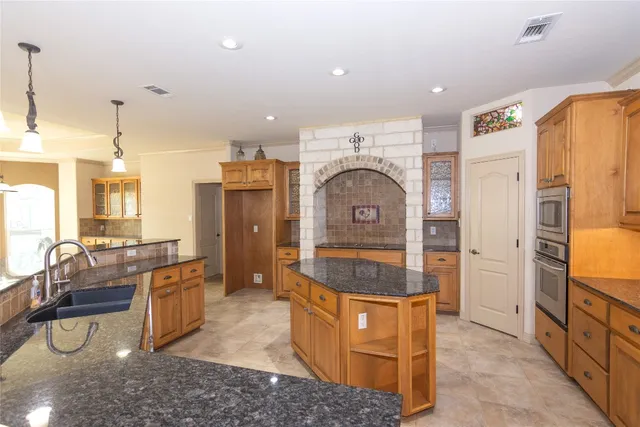a spacious bathroom with stainless steel appliances granite countertop a sink and a refrigerator