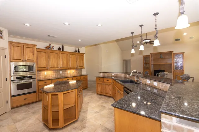 a kitchen with stainless steel appliances granite countertop a sink and cabinets