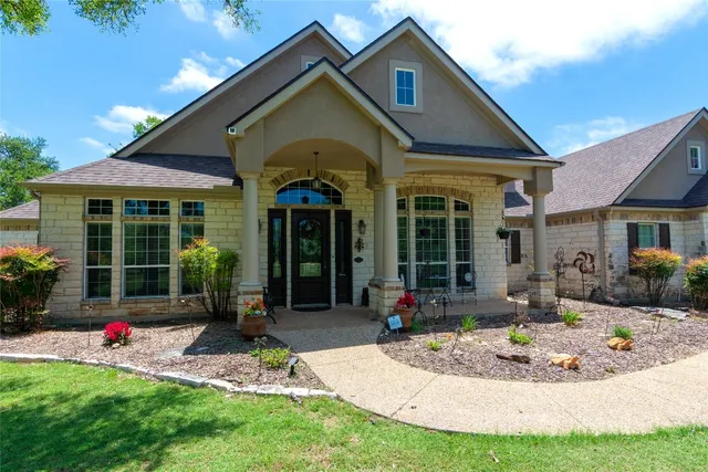 a front view of a house with porch and garden