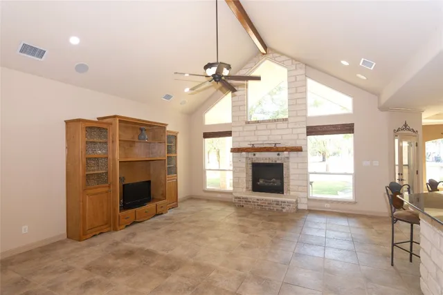 a view of an empty room with a fireplace and a window
