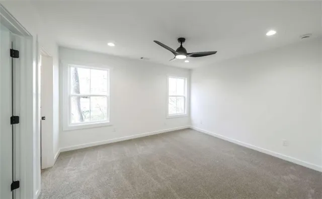en empty room with windows and ceiling fan