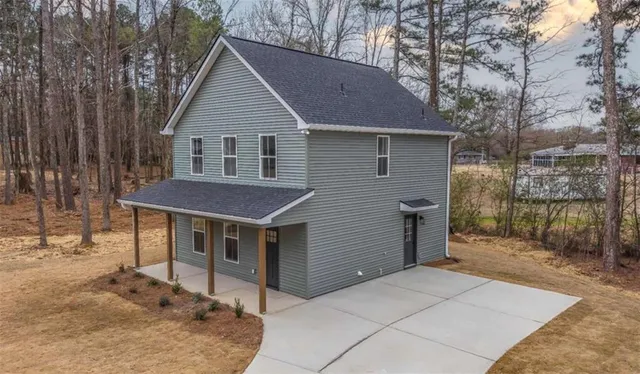 a view of house with backyard and trees