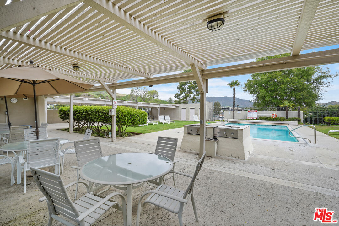 30473 Mulholland Highway, Unit 174 Agoura Hills, CA 91301 - Photo 30 of 36 a view of a patio with a table chairs and a backyard