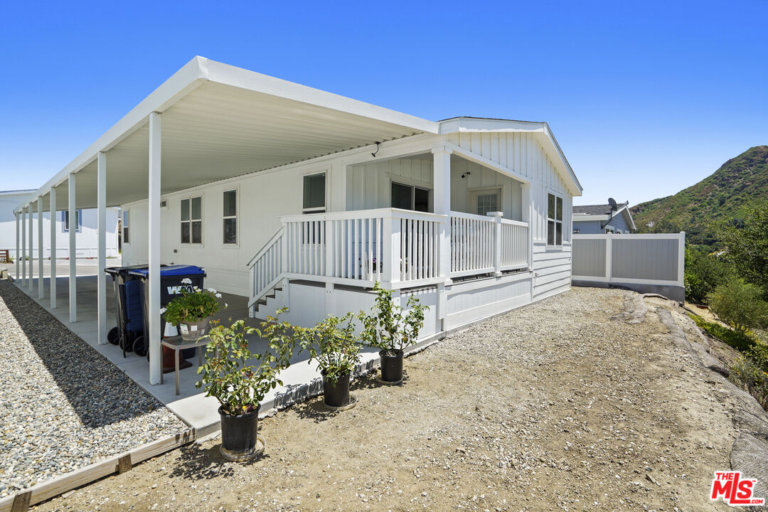 30473 Mulholland Highway, Unit 174 Agoura Hills, CA 91301 - Photo 3 of 36 a front view of a house with a garden
