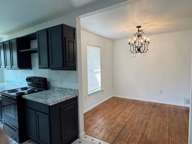 a kitchen with granite countertop a stove a sink and a microwave
