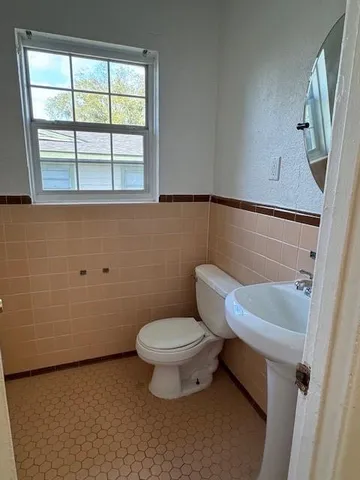 a bathroom with a toilet sink and window