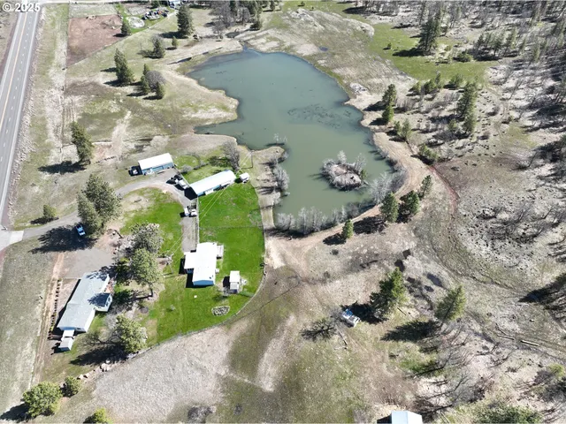 an aerial view of a house with a yard and lake view