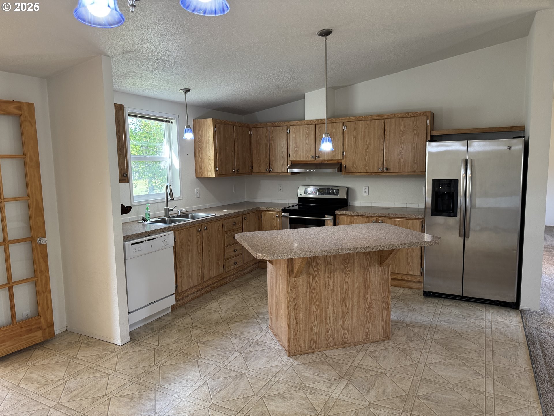 1924 Highway 97 Goldendale, WA 98620 - Photo 14 of 40 a kitchen with stainless steel appliances a sink a stove a refrigerator cabinets and a window