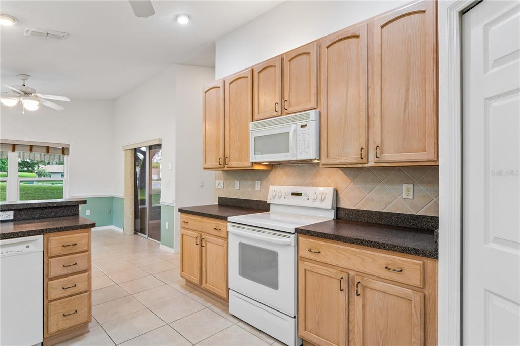 11330 Leeds Drive Spring Hill, FL 34609 - Photo 12 of 78 a kitchen with stainless steel appliances granite countertop white cabinets and sink