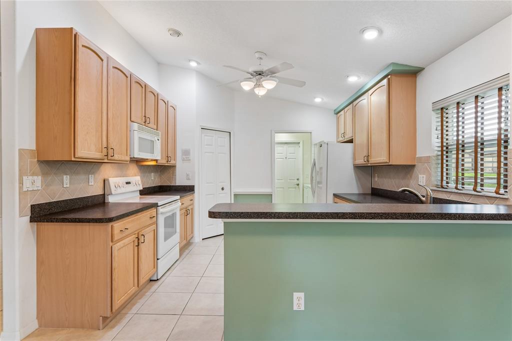 11330 Leeds Drive Spring Hill, FL 34609 - Photo 10 of 78 a kitchen with stainless steel appliances granite countertop a sink a stove and cabinets