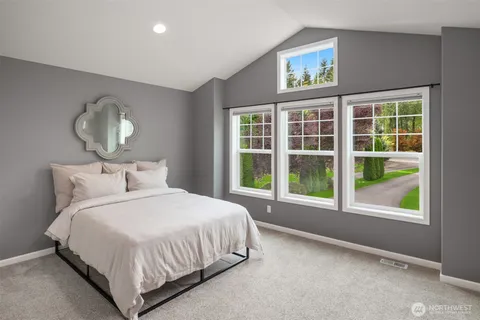 a bedroom with a bed and a large window