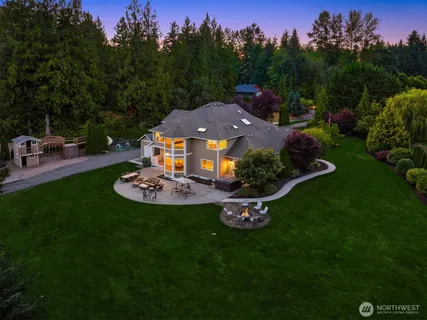 an aerial view of a house with garden space and trees all around