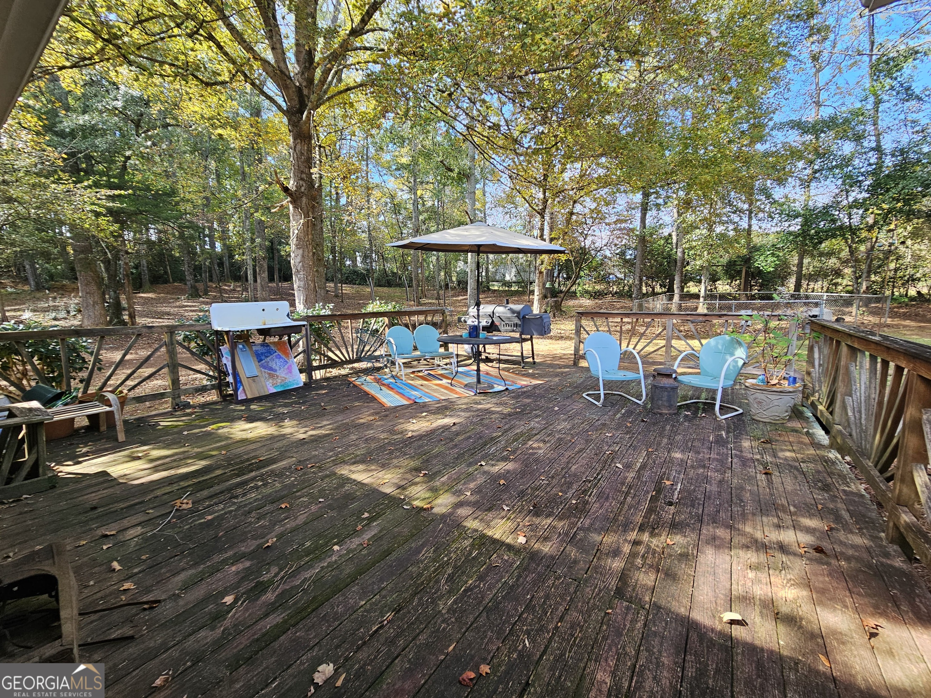 228 Honeysuckle Road Monticello, GA 31064 - Photo 26 of 35 a view of a patio with table and chairs under an umbrella with large trees