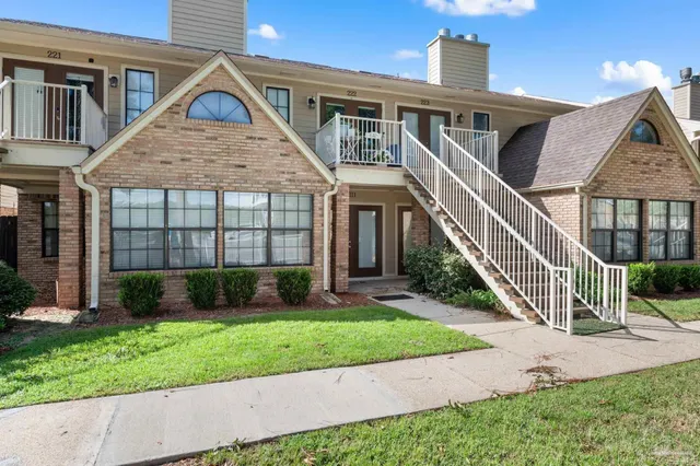 a front view of a house with a yard and potted plants