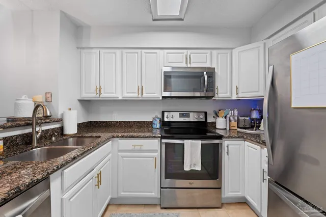 a kitchen with granite countertop a sink and steel appliances