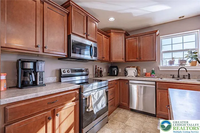 a kitchen with stainless steel appliances granite countertop a sink a stove and cabinets