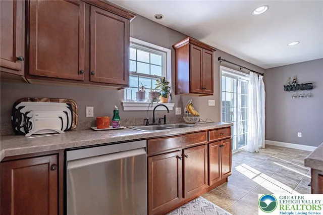a kitchen with stainless steel appliances granite countertop a sink a stove and cabinets
