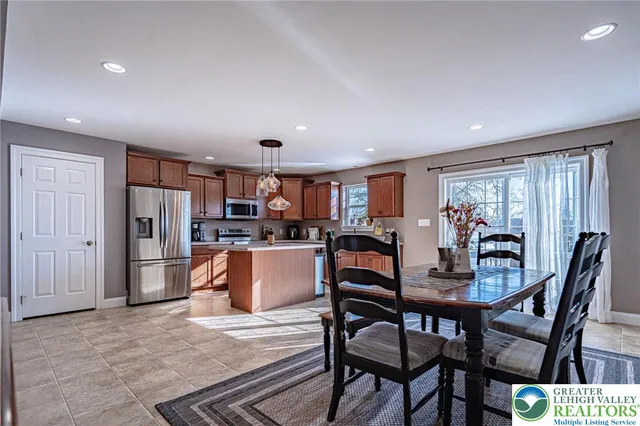 a kitchen with stainless steel appliances granite countertop a dining table and chairs