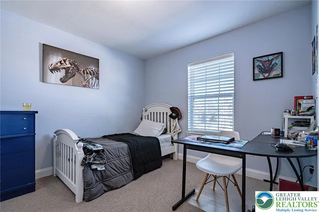 a bedroom with a bed and a painting on the wall