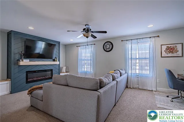 a living room with furniture a flat screen tv and a window