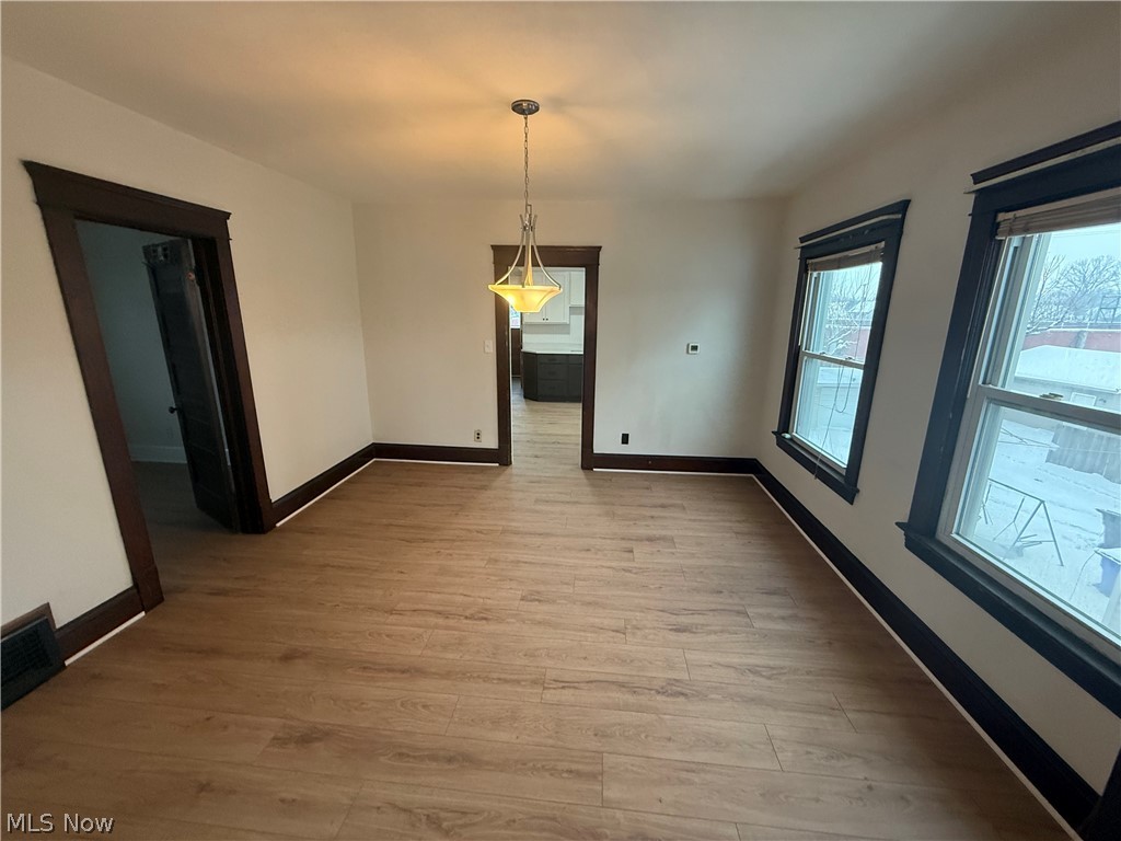 3612 Riverside Avenue Cleveland, OH 44109 - Photo 9 of 22 Spacious interior room featuring wood-finish flooring, dark trim accents, and a central pendant light fixture