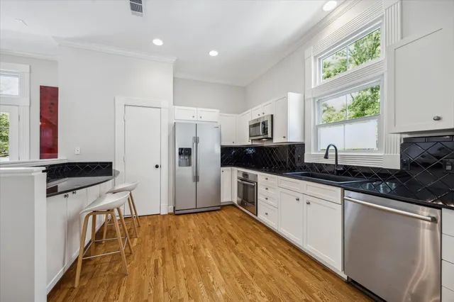 a kitchen with granite countertop a stove a sink and a refrigerator