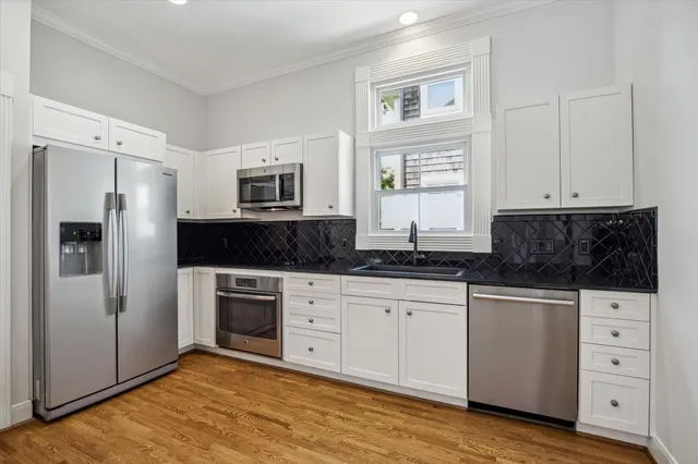 a kitchen with stainless steel appliances granite countertop a stove a sink and a refrigerator