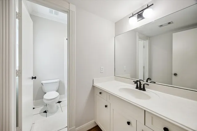 a bathroom with a sink a toilet and a mirror
