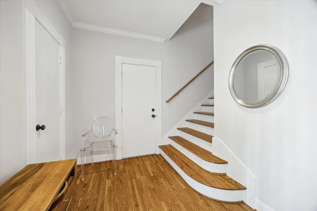 a view of a bedroom with wooden floor and white walls