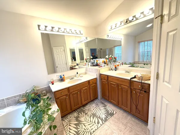 a bathroom with a sink mirror and a bathtub