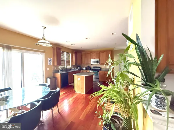 a kitchen with stainless steel appliances granite countertop a refrigerator a sink dishwasher a oven with white cabinets and wooden floor