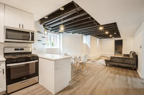 a kitchen with granite countertop a stove and a wooden floor