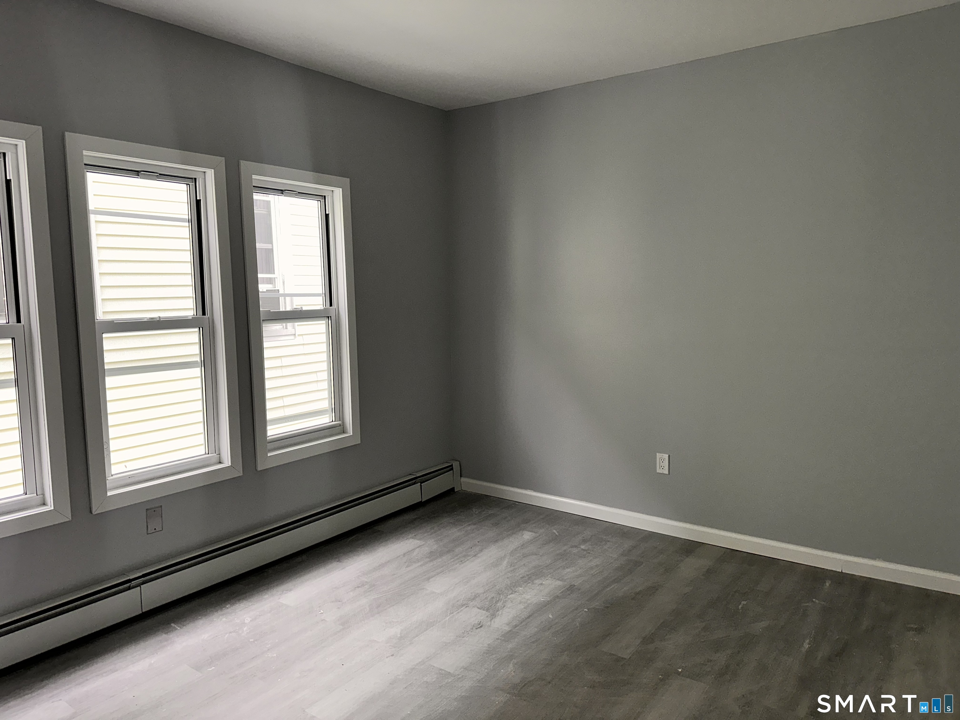 240 Madison Avenue Bridgeport, CT 06604 - Photo 11 of 21 an empty room with wooden floor and windows