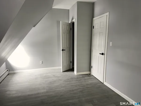 a view of an empty room with wooden floor
