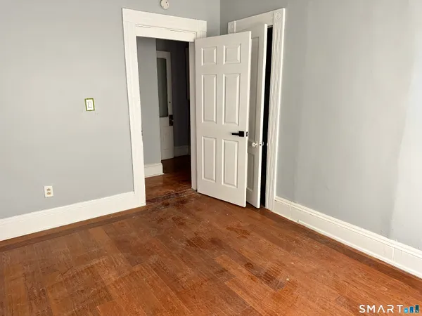 an empty room with closet and mirror