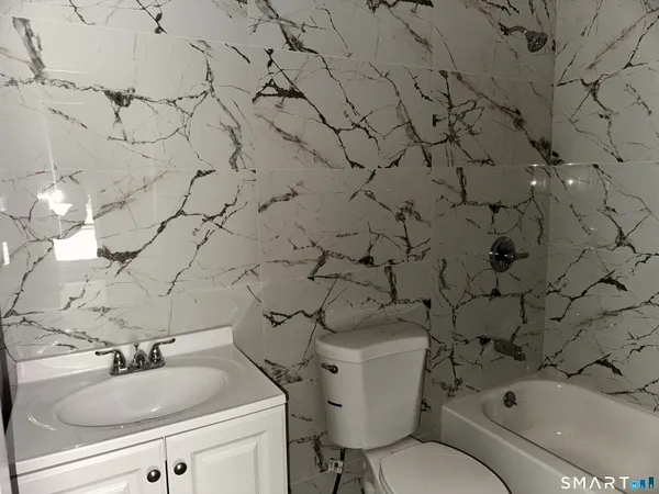 a bathroom with a sink and mirror with toilet