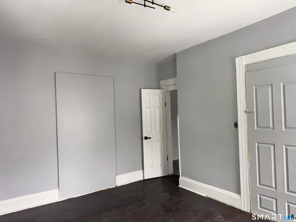 an empty room with wooden floor and mirror